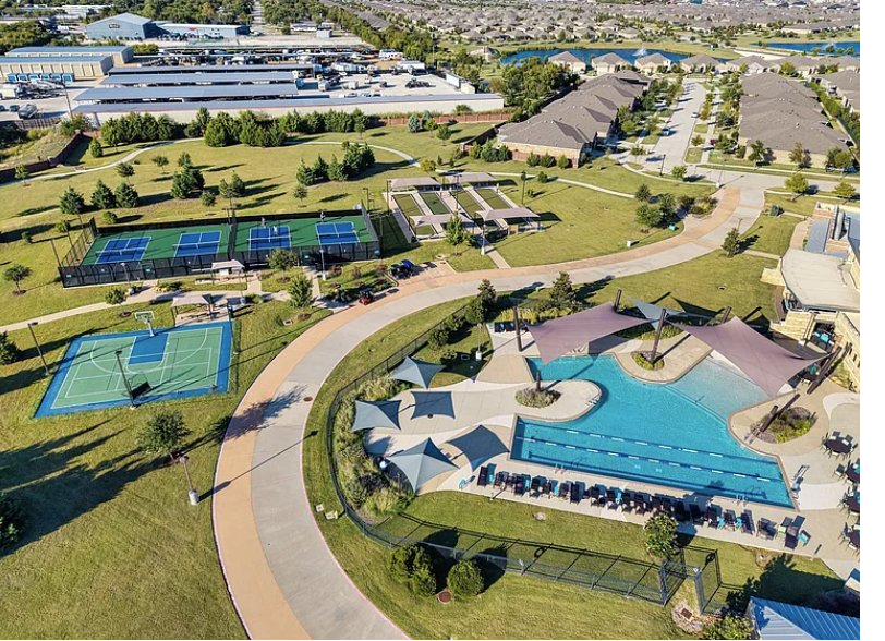 Aerial view of a master-planned community amenity center with pools and sports courts